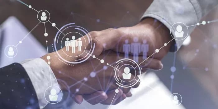 Two business people shaking hands, surrounded by digital network icons symbolizing partnership.